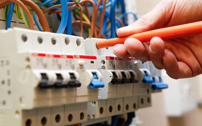 Domestic Electrical Services: electrician switching on circuit breakers inside a domestic consumer unit