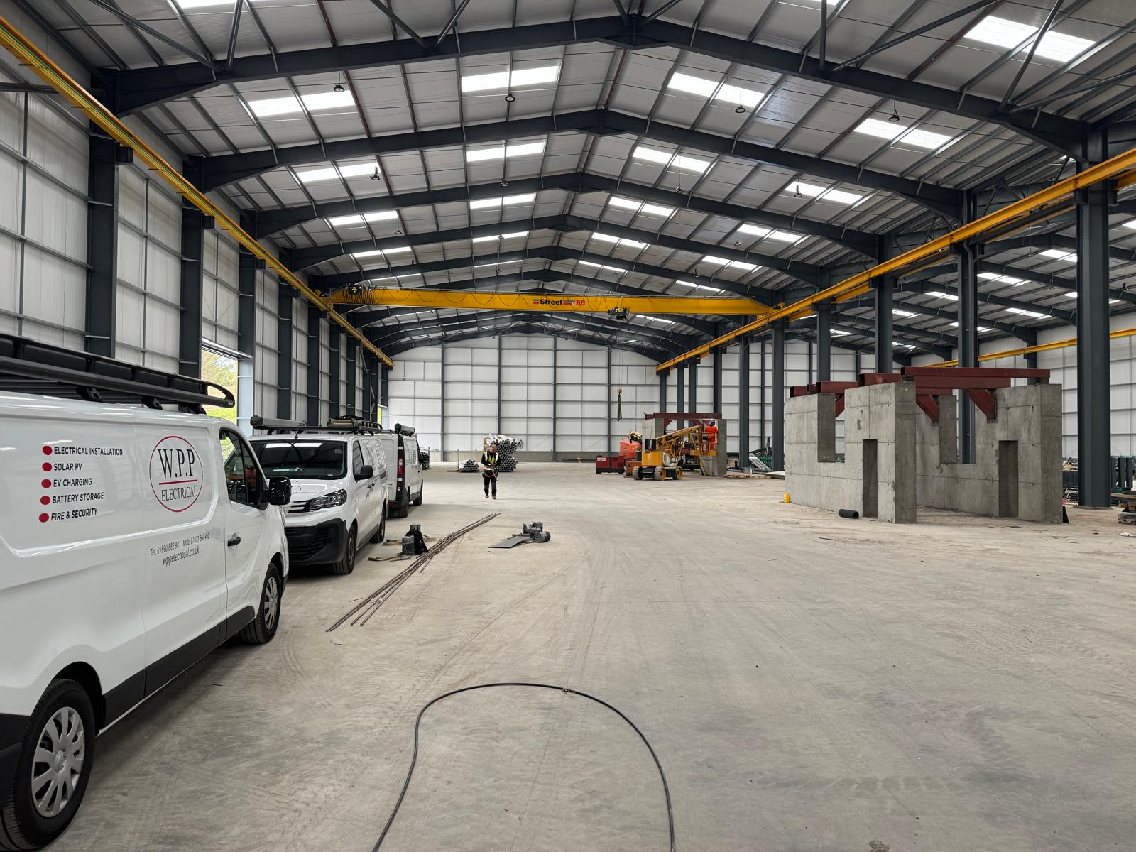 WPP Electrical vans inside a new steel-framed warehouse during an industrial electrical fit-out